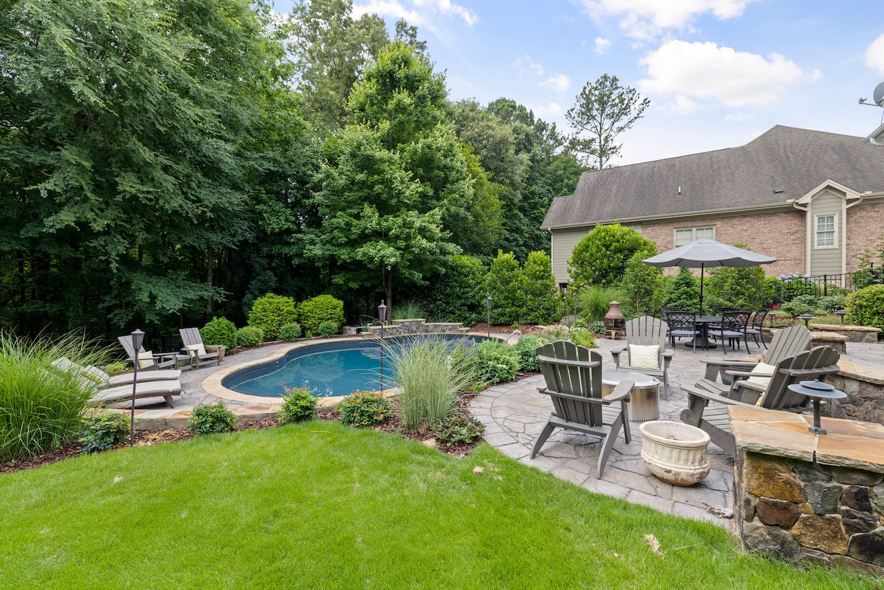 A backyard pool equipped with home additions for summer relaxation