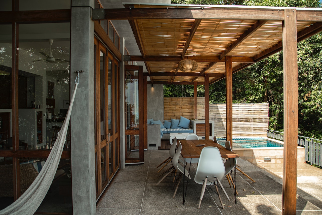 A small pool next to a patio with minimalist furniture.