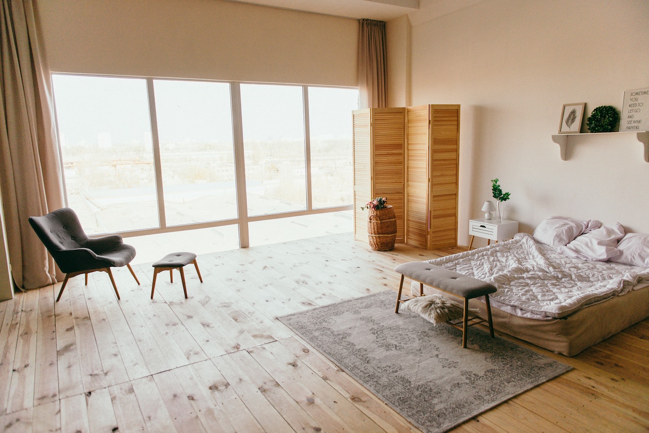 A bedroom with wooden flooring.