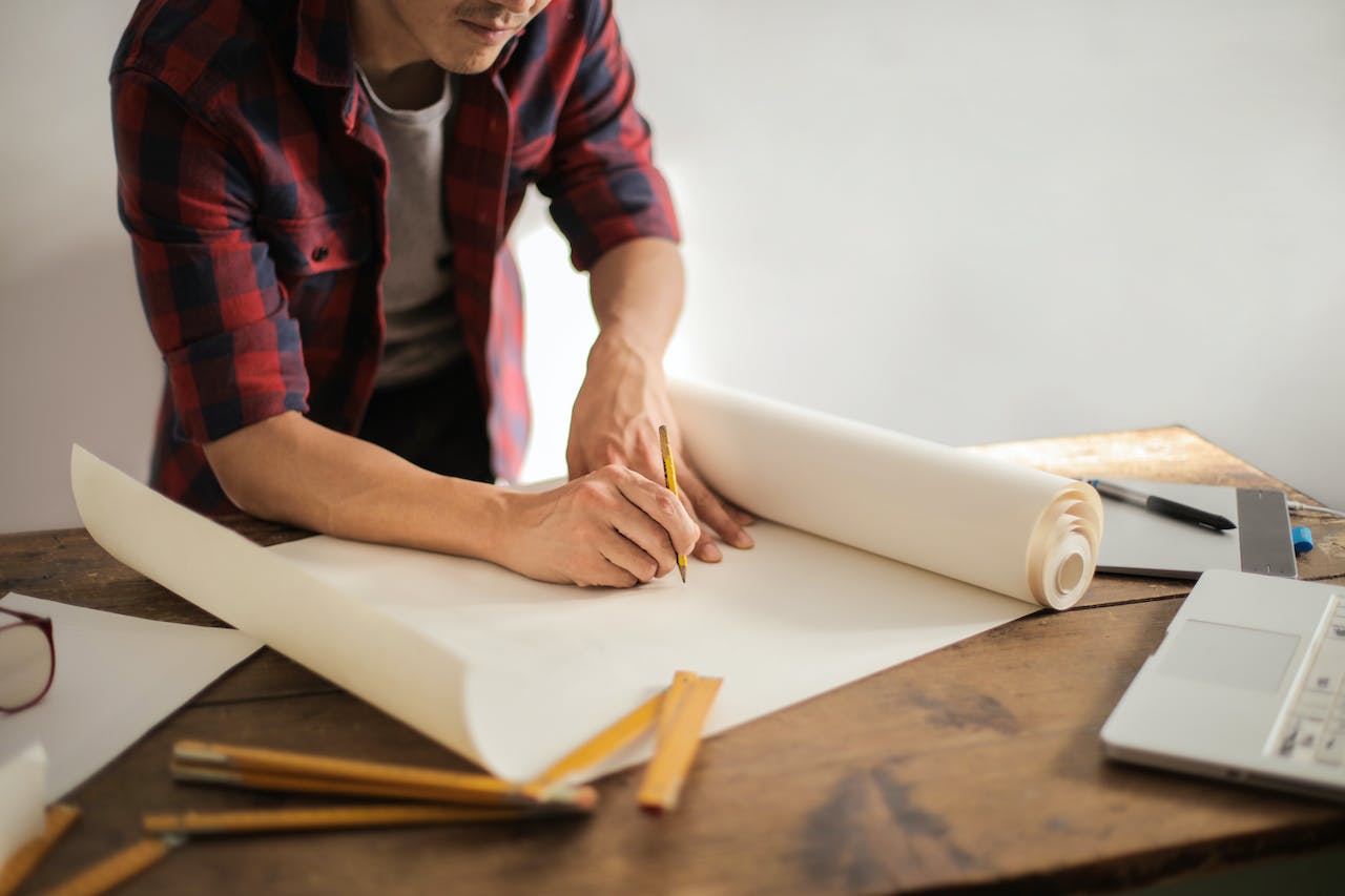 A man drawing a plan for a basement transformation.